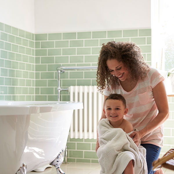 woman drying son after bath